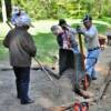 Ken Schrader dumps a load of gravel and dirt in the walkway for Sylvia Garde to spread.