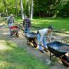 “Drivers” start their “trucks” to dump loads of gravel into the walkway.